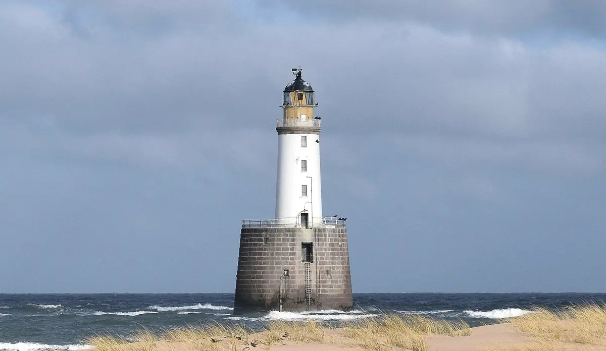 Il faro di Rattray Head che spunta dal mare, visto dalle dune