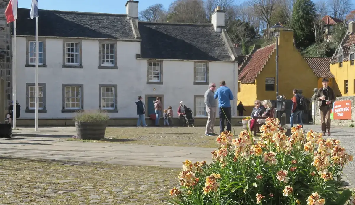 La piazza acciottolata del villaggio di Culross, con le case bianche e ocra